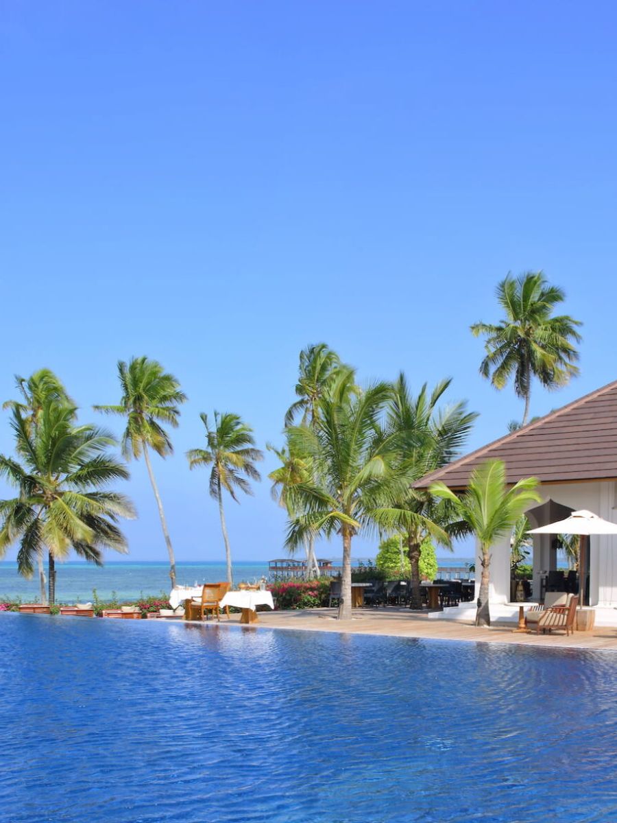 The Residence Zanzibar - Pool mit Palmen und Blick auf das Meer