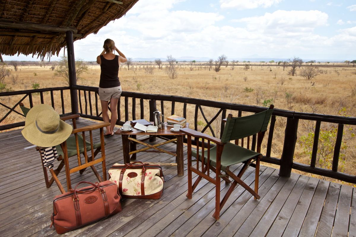 Urlauberin beobachtet die Flora und Fauna von der Veranda ihrer Lodge in Tansania