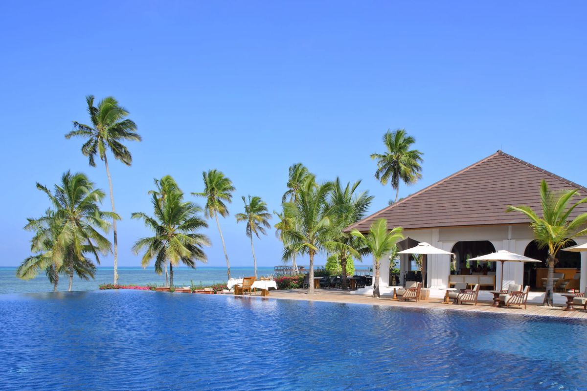 The Residence Zanzibar - Pool mit Palmen und Blick auf das Meer