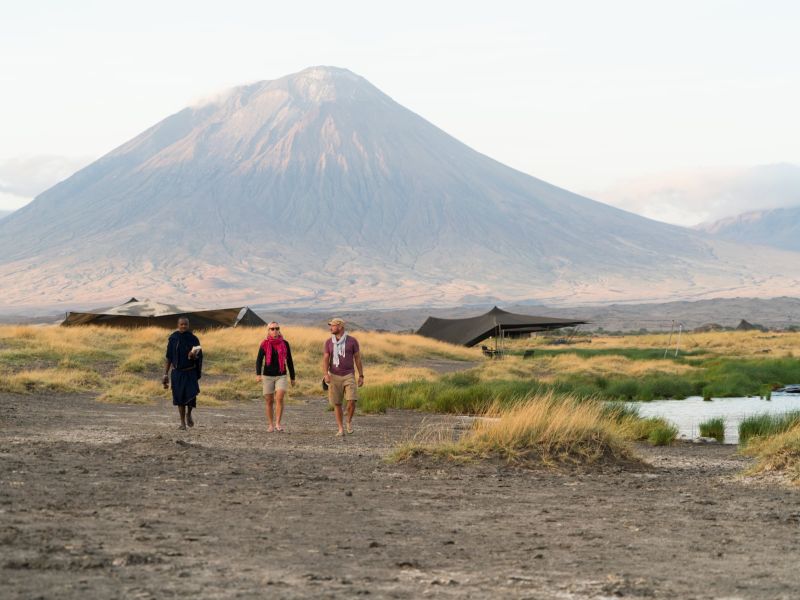 Kleine Reisegruppe beim Trekking in der Nähe des Natronsees. Im Hintergrund der Ol Donyo Lengai.
