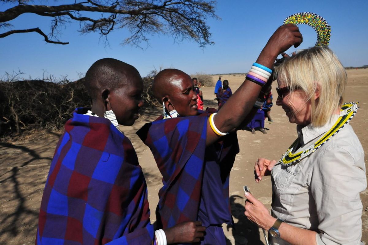 Reiseteilnehmerin wird von Mitgliedern eines Stammes herzlich begrüsst